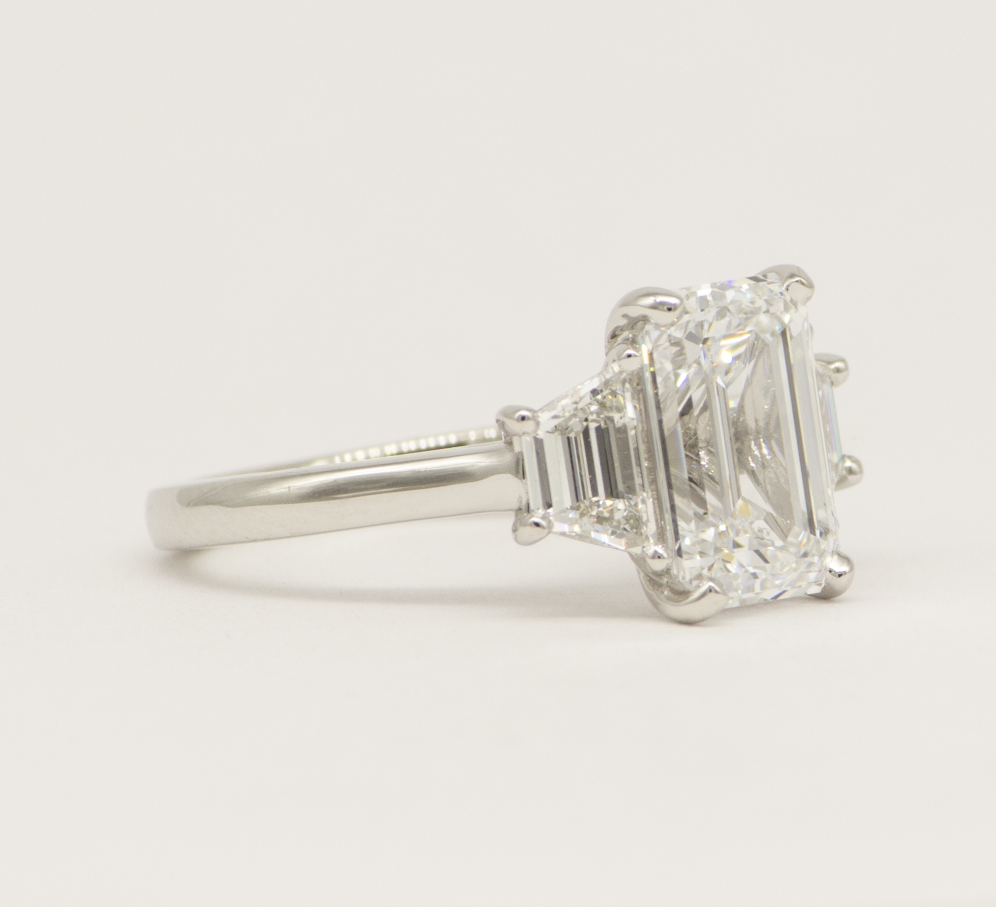 three stone emerald cut ring with step cut trapazoids